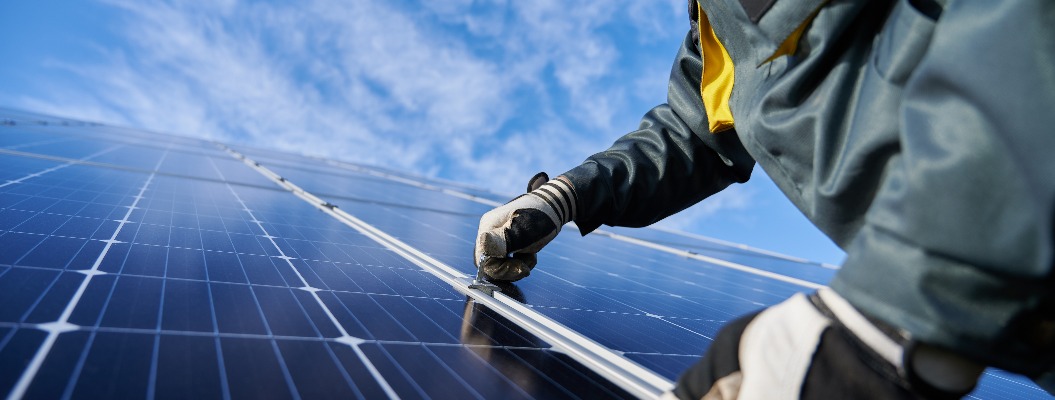 Ein Arbeiter repariert ein Photovoltaik-Solarmodul.